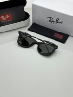 Trendy black sunglasses with green shaded lens